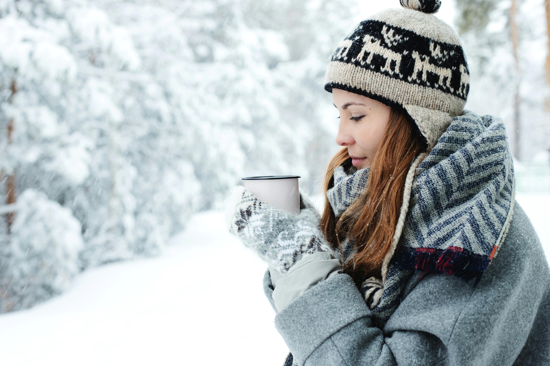 Symbolbild für Jin Shin Jyutsu bei Bronchitis: Frau in winterlicher Landschaft mit Teetase