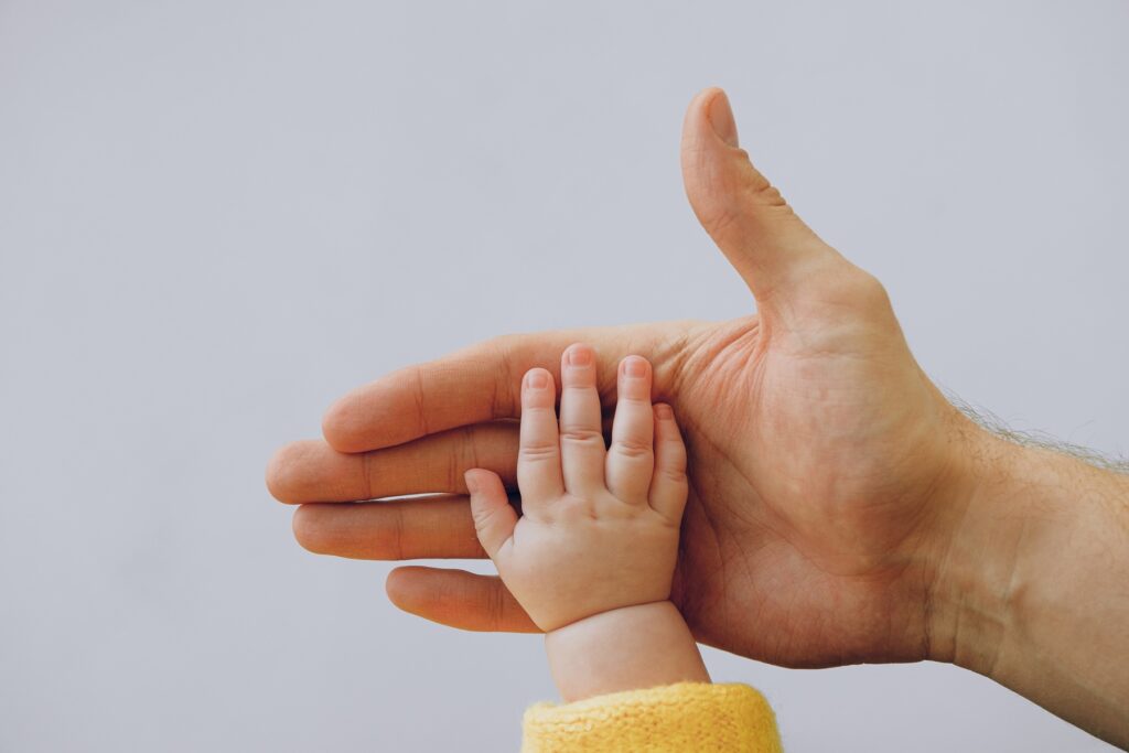 Symbolbild Jin Shin Jytusu gefährlich: Babyhand liegt vertrauensvoll in großer Hand