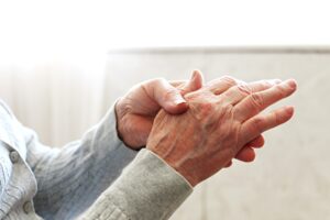 Jin Shin Jyutsu bei Arthrose im Finger: älterer Mensch strömt seine Hände