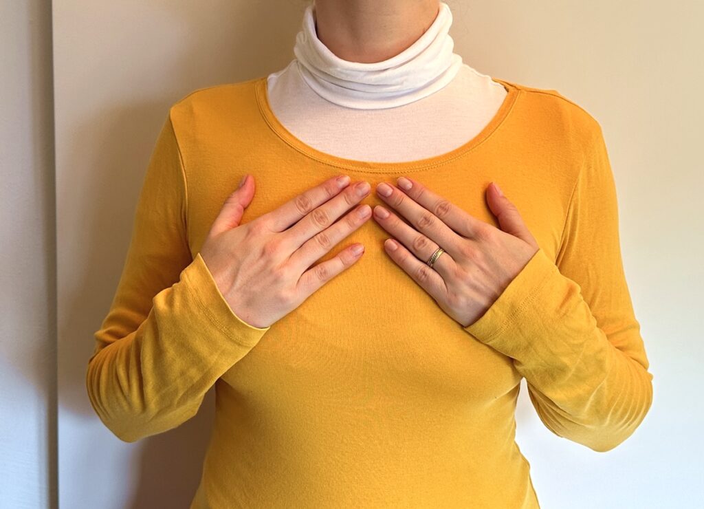 Strömen in der Schwangerschaft: Frau legt Hände nebeneinander auf Brust
